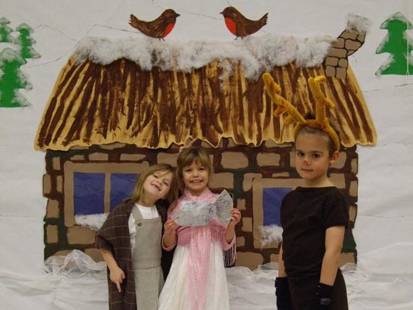 A photo of children standing in front of a snowey background